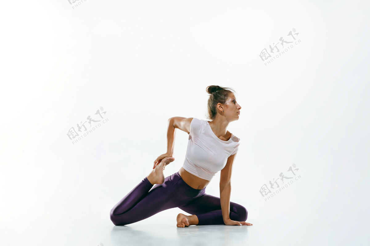力量运动型年轻女性 在白色工作室背景下做瑜伽练习适合灵活的女性模特练习健康生活方式的概念 身体和心理发展之间的自然平衡实践能量运动