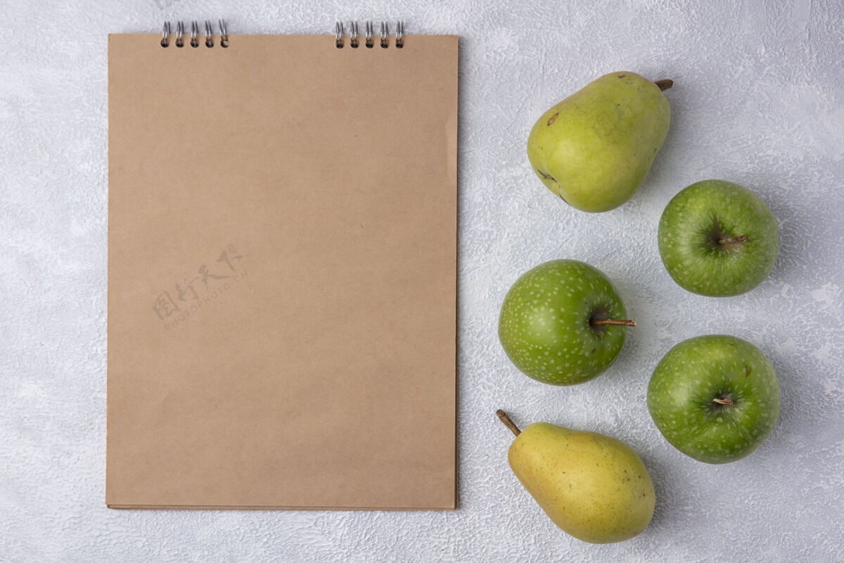 空格顶视图复制空间米色记事本与绿色苹果和梨在白色背景白色复制顶部