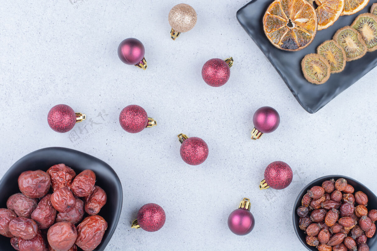 圣诞饰品大理石表面有各种干果和圣诞球小吃美味节日