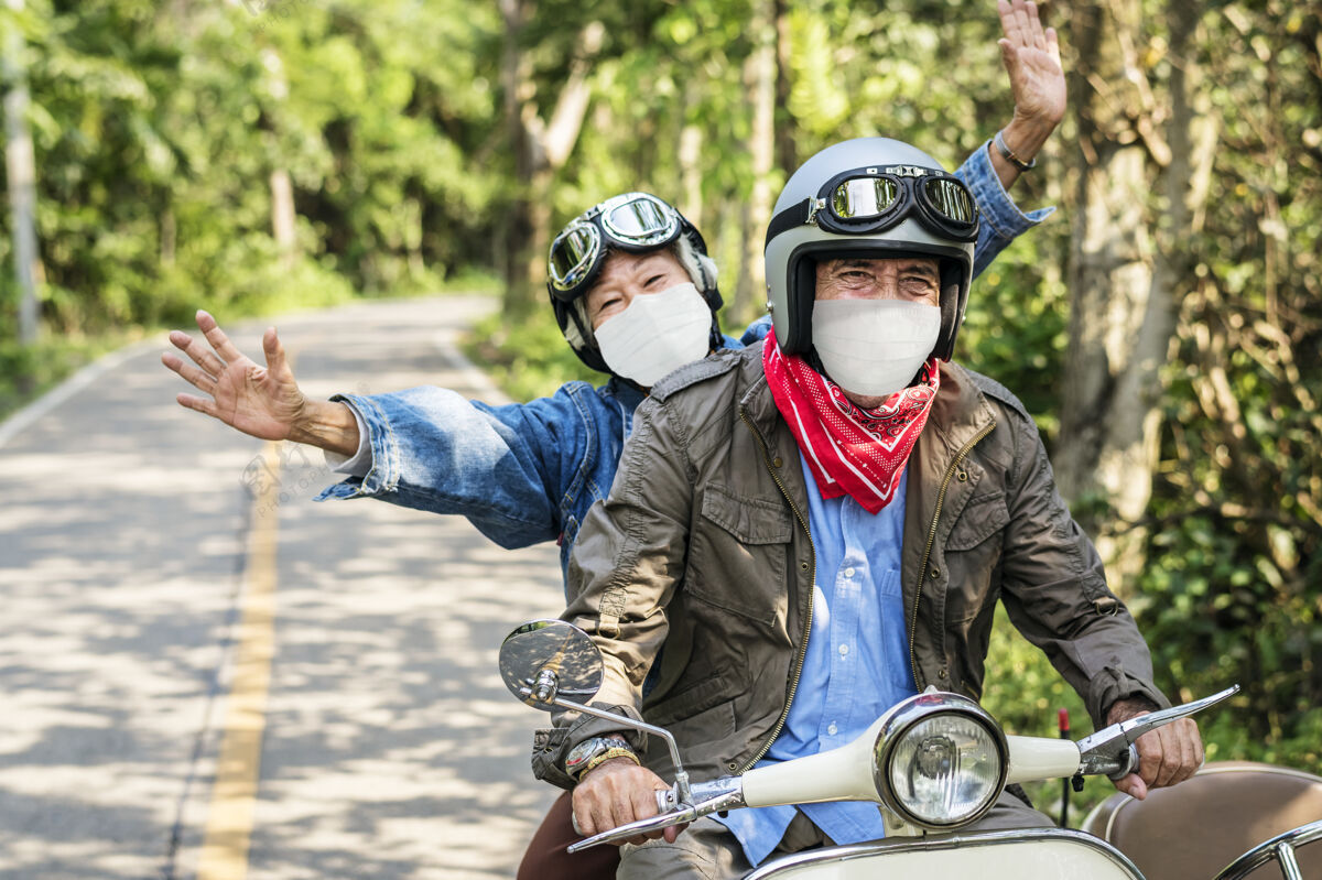骑老年夫妇骑着踏板车在新的正常旅行面具老年人中国人