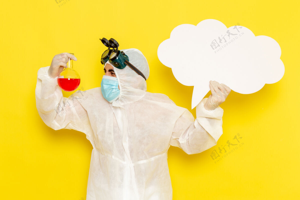 科学正面图身着特殊防护服的男科学工作者手持黄色表面上带有红色溶液大白字的烧瓶西装服装解决方案