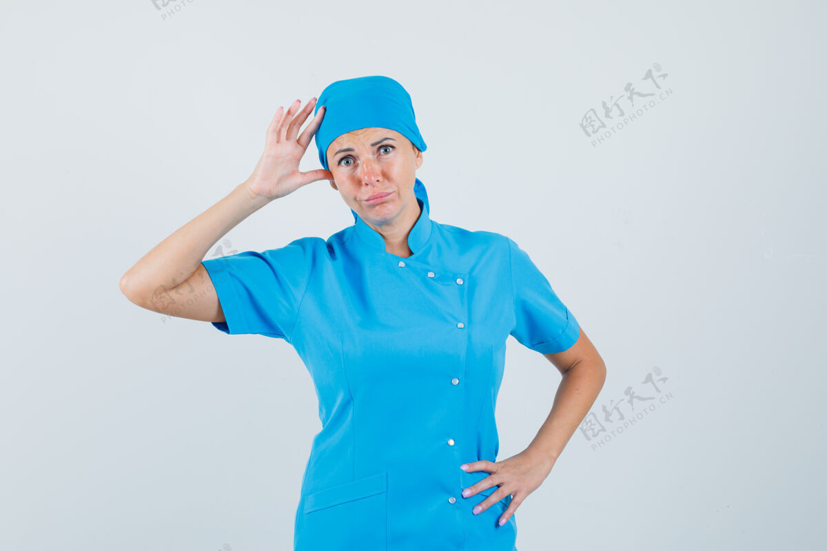 看台穿着蓝色制服的女医生手挽着手 看上去很困惑前视图肖像年轻预防