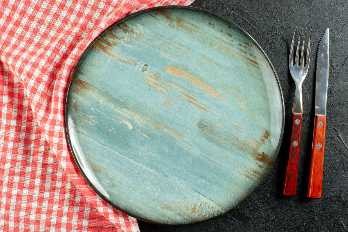 刀叉顶上近看刀叉红白方格餐巾纸圆盘子在深色的桌子上容器培养皿桶