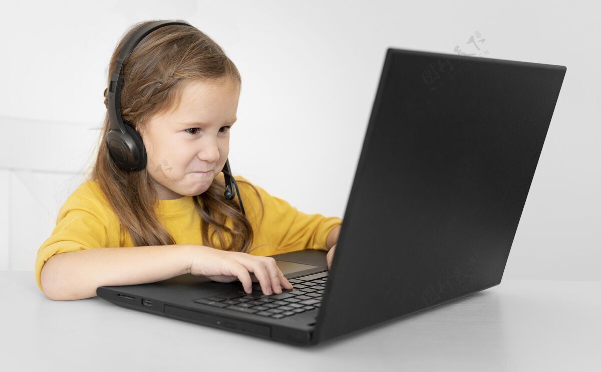 业余爱好年轻女孩用带耳机的笔记本电脑娱乐娱乐电子