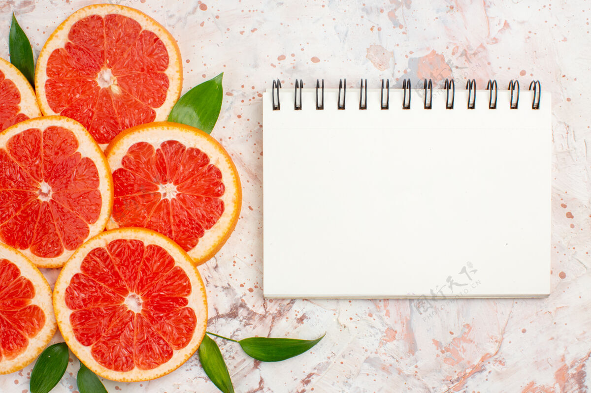 葡萄柚片俯瞰美味的柚子片裸体桌上的记事本维生素酸葡萄柚