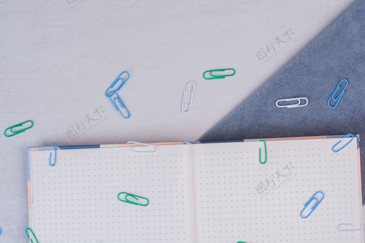 配件彩色的夹子散落在白色的笔记本表面空的设备笔记本