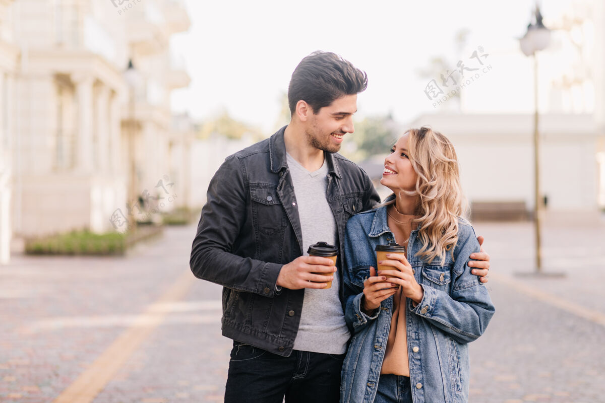 积极迷人的女孩在约会时看着男朋友情侣喝咖啡的户外画像人城市约会