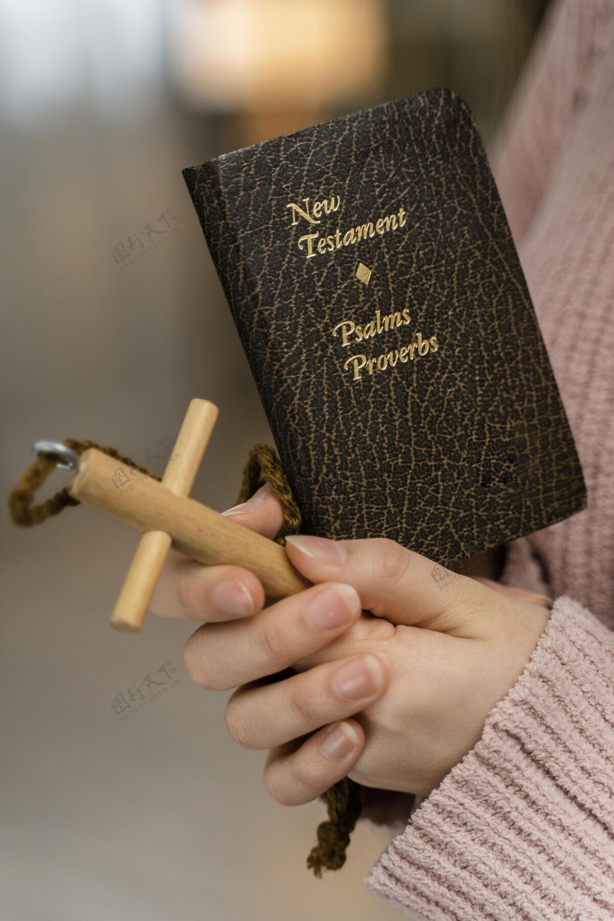 女人妇女用木十字架和圣经祈祷的侧视图女人垂直圣经