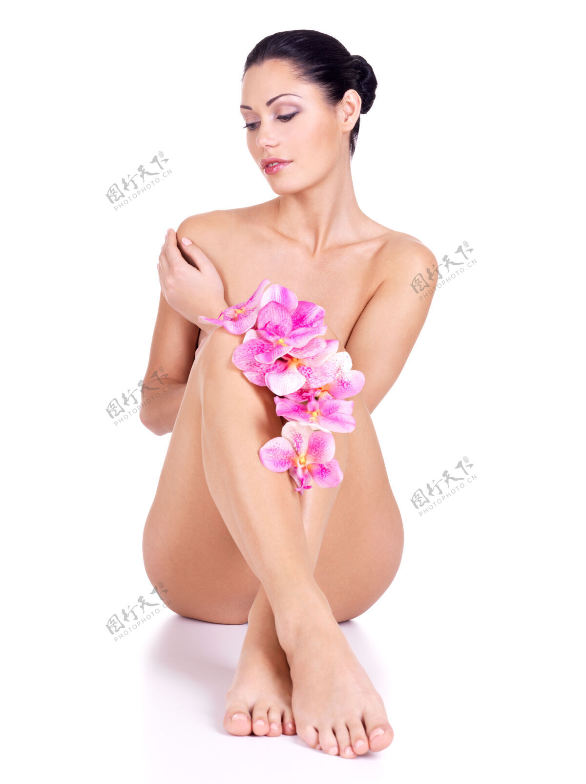 腿部裸体的年轻女子坐在白色的花坛上女人正面皮肤