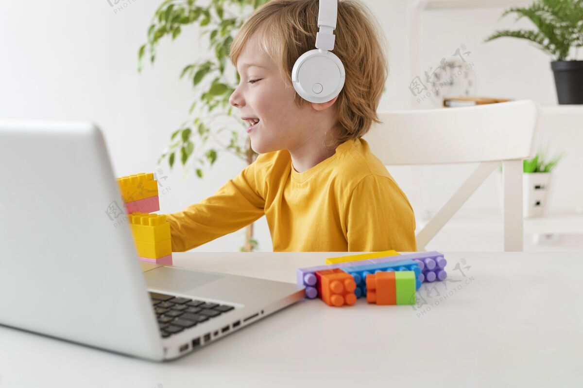 爱好小男孩在家里用耳机和笔记本电脑年轻消遣娱乐