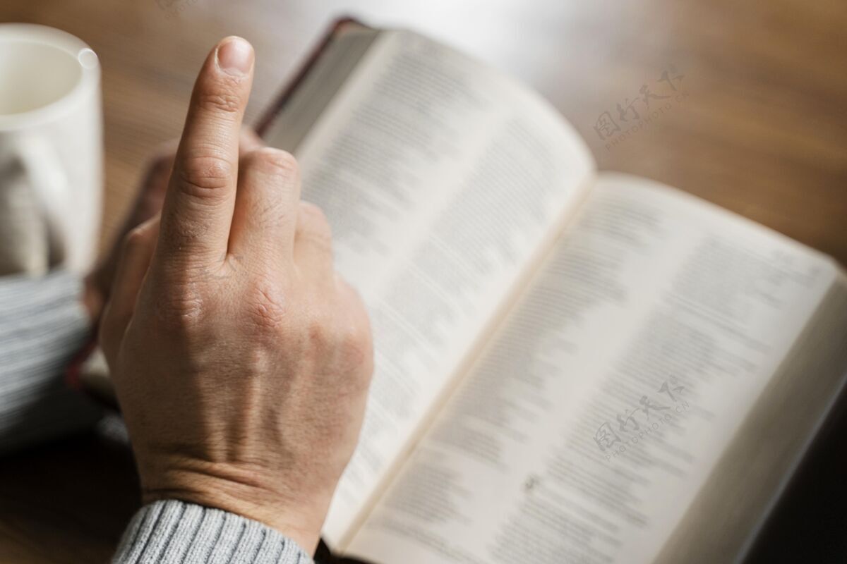 精神高角度的人读圣经和手指人崇拜圣经