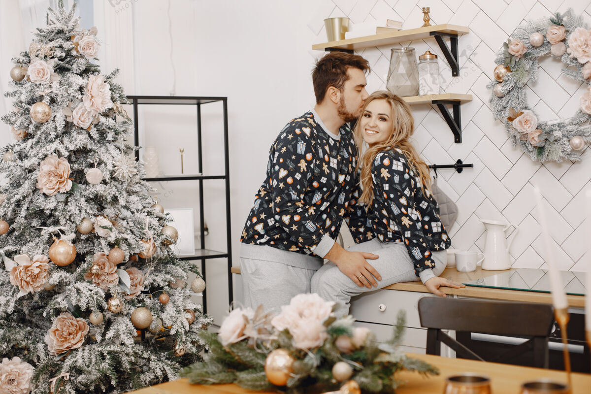 房子穿着圣诞老人装潢的人们穿着睡衣的男人和女人厨房里的家人女朋友浪漫圣诞