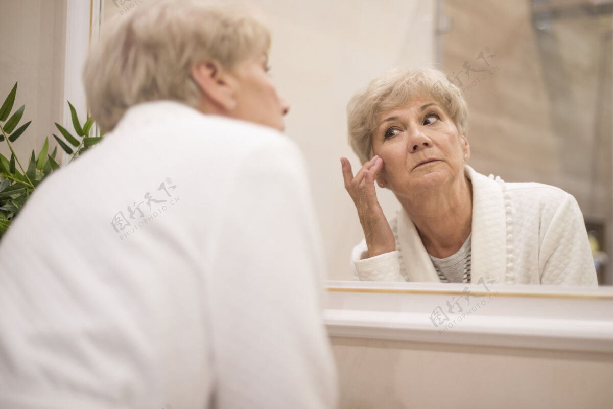 老年人镜子里的埃德里女人的倒影担心看着人类