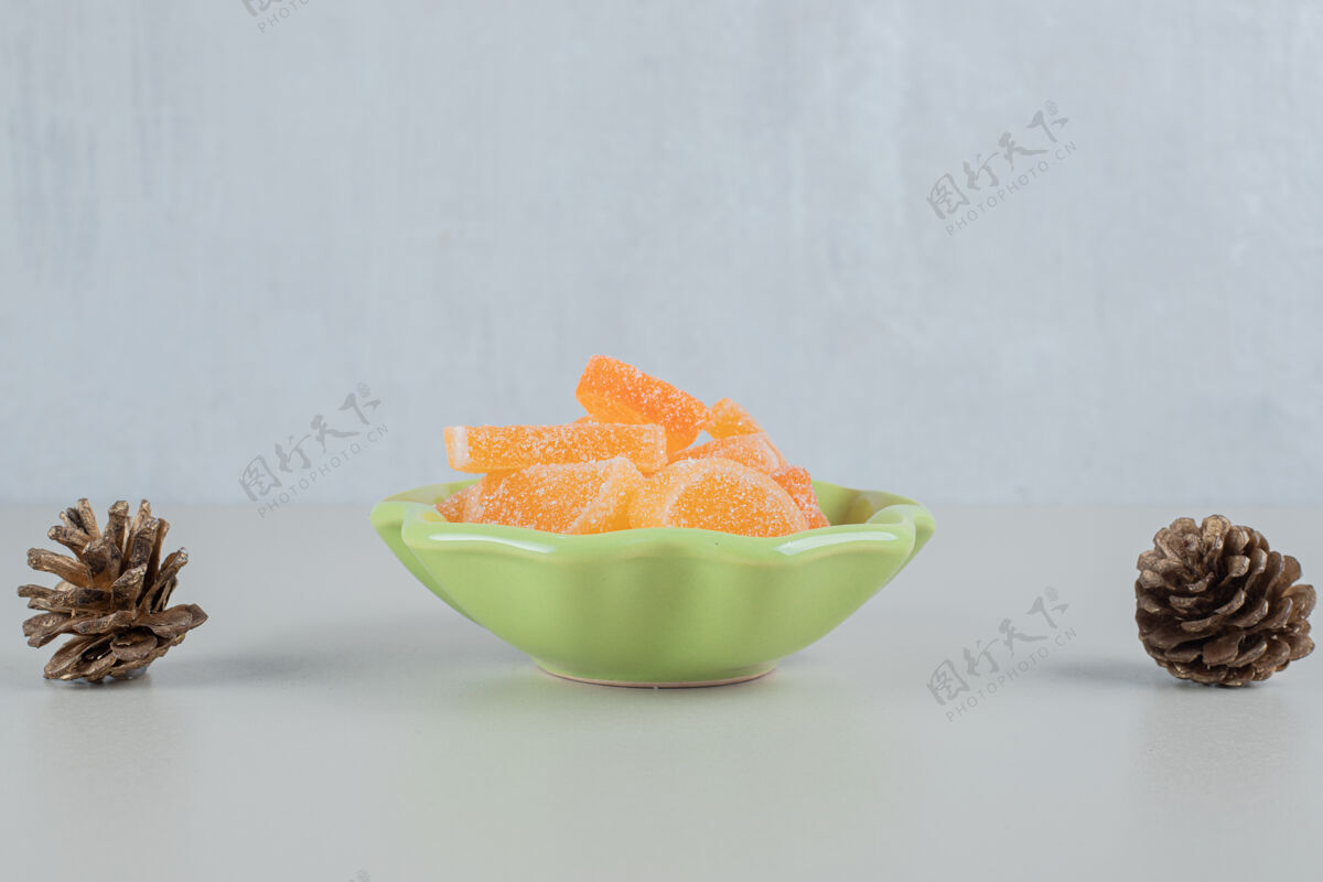 甜食一盘绿色的桔子糖果冻糖果和松果美味盘子糖果