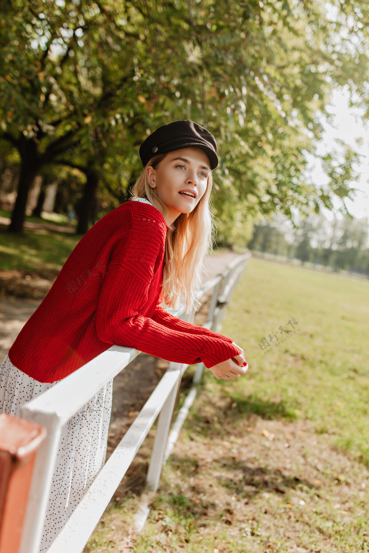 女人美丽的金发碧眼的自然化妆的女孩在公园的栅栏边摆姿势漂亮的女人穿着漂亮的饰物看起来很惊讶苗条户外微笑