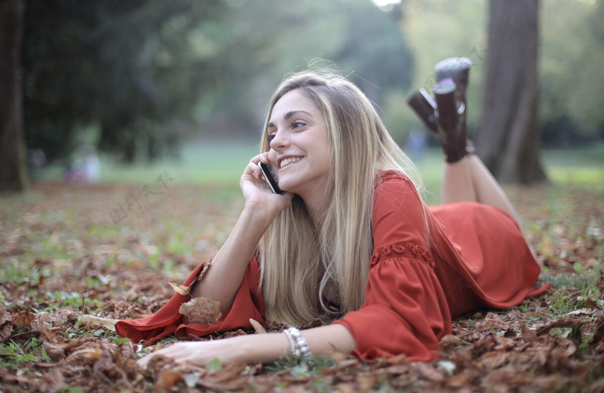 通话躺在森林地板上打电话的女人联系漂亮交谈
