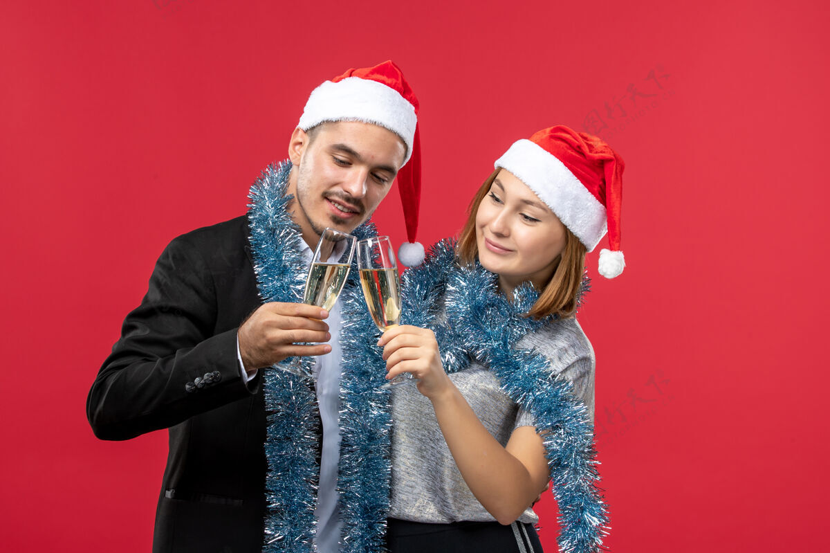 肖像前视图年轻夫妇刚刚庆祝新年在红地板爱圣诞晚会圣诞节风景微笑