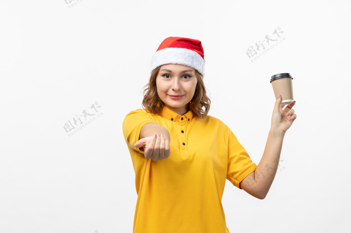 风景正面图年轻女快递员用咖啡在白墙上统一服务送货圣诞节制服工作