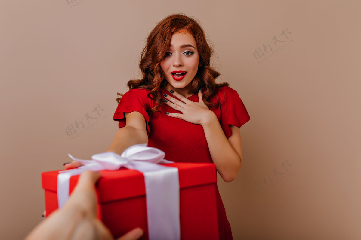 圣诞礼物惊喜优雅的女人看着新年礼物室内迷人的女孩享受圣诞时光的画像室内礼物新