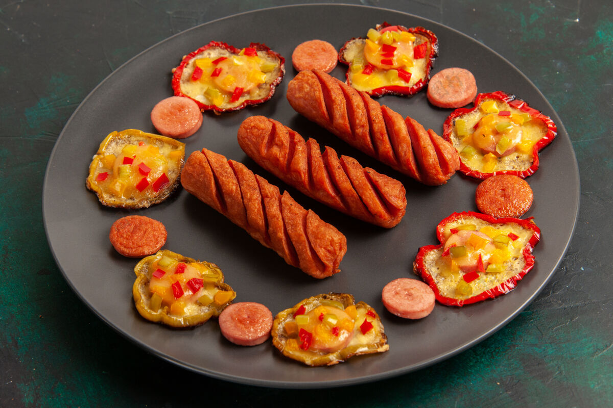 生的前视图煮熟的甜椒和香肠在黑暗的表面板内营养品寿司香肠