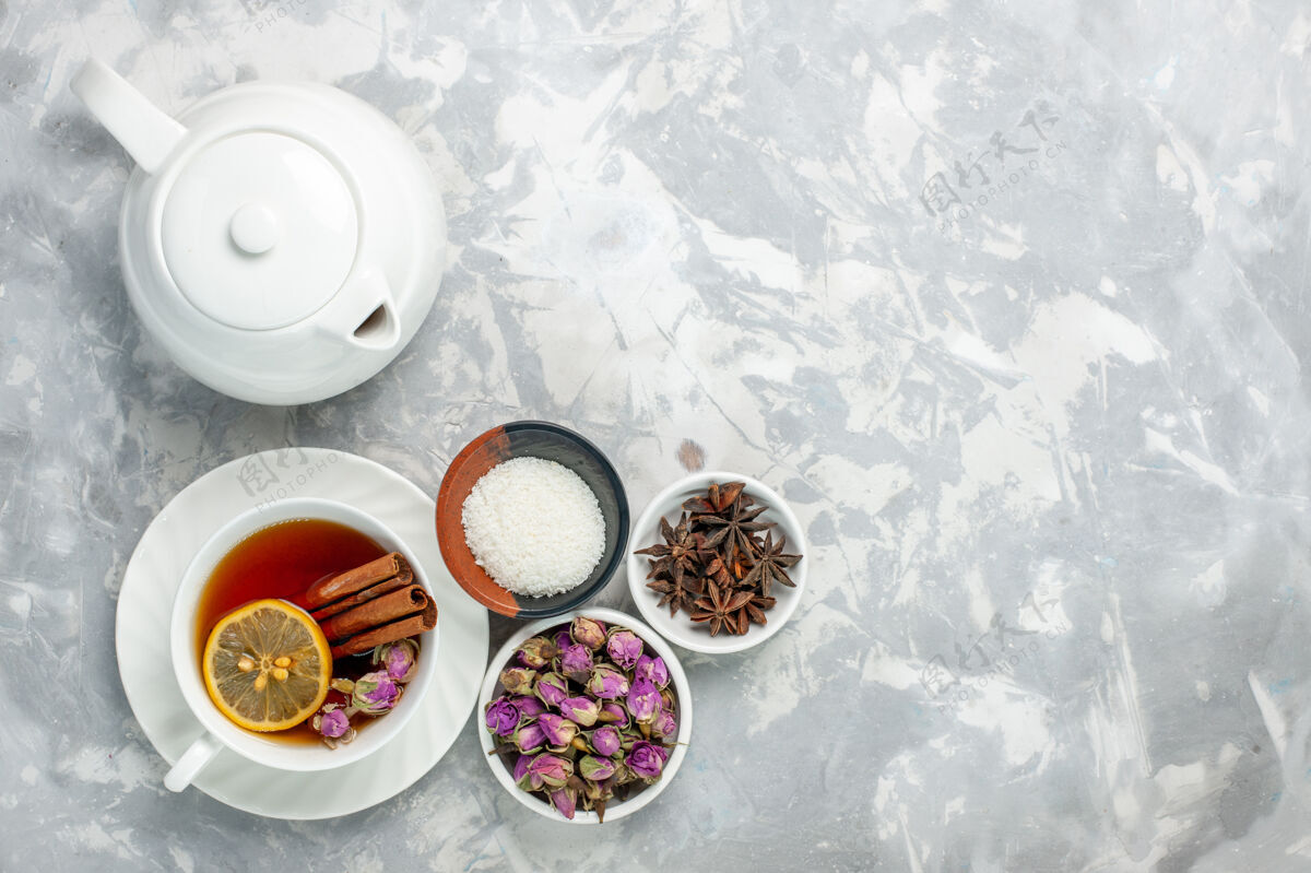 饮料俯瞰一杯茶 茶壶和白色表面上的花朵茶花硬币