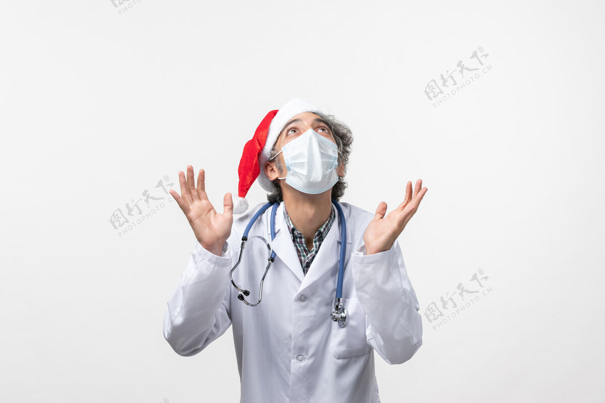 大流行正面图：男医生带着无菌口罩在白色办公桌上共济病毒大流行新年医生医院制服