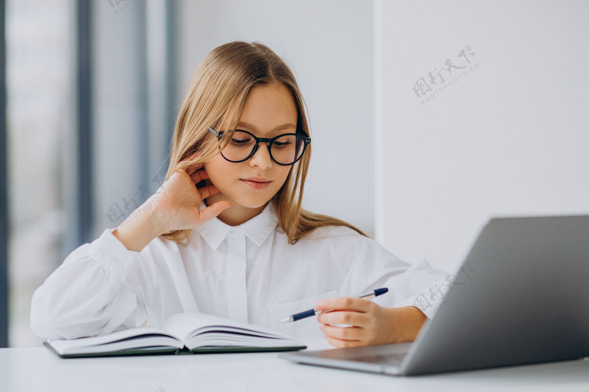 人可爱的女孩在家里用电脑学习青少年学习钢笔