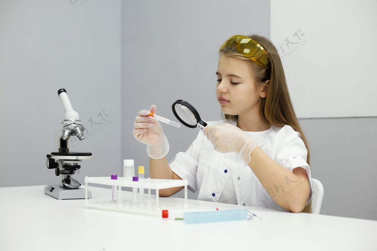 科学戴着安全眼镜和显微镜的女科学家青年放大镜实验室