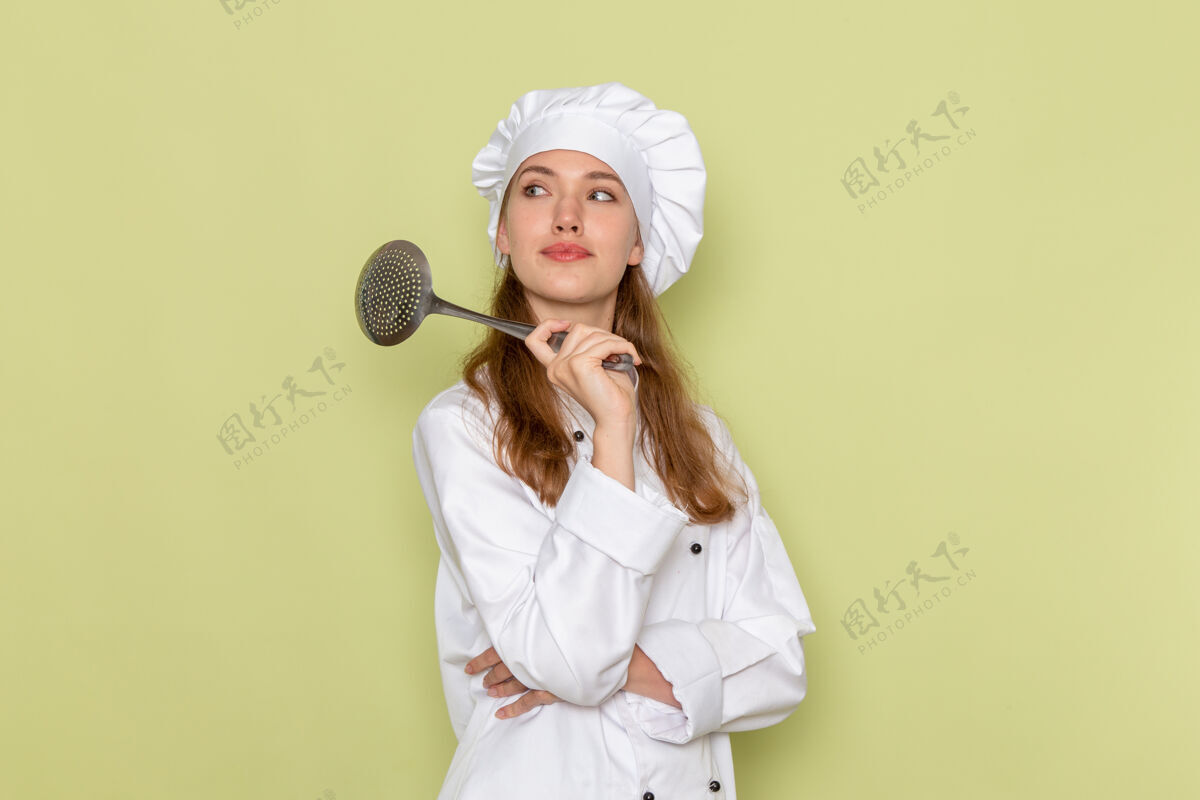 银身穿白色厨师服的女厨师手持大银勺站在浅绿色的墙上漂亮肖像成人