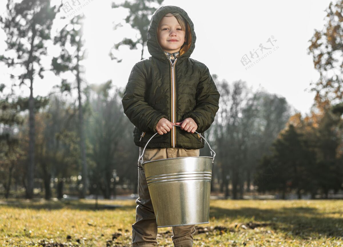 桶户外抱着水桶的小男孩的正面图培养园艺自然