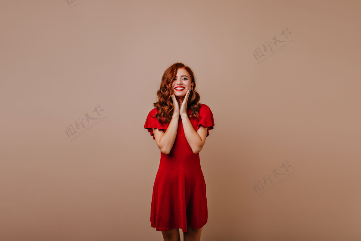 肖像温文尔雅的姜汁女孩表达幸福华丽的高加索女士在红色礼服摆姿势活力表情卷曲
