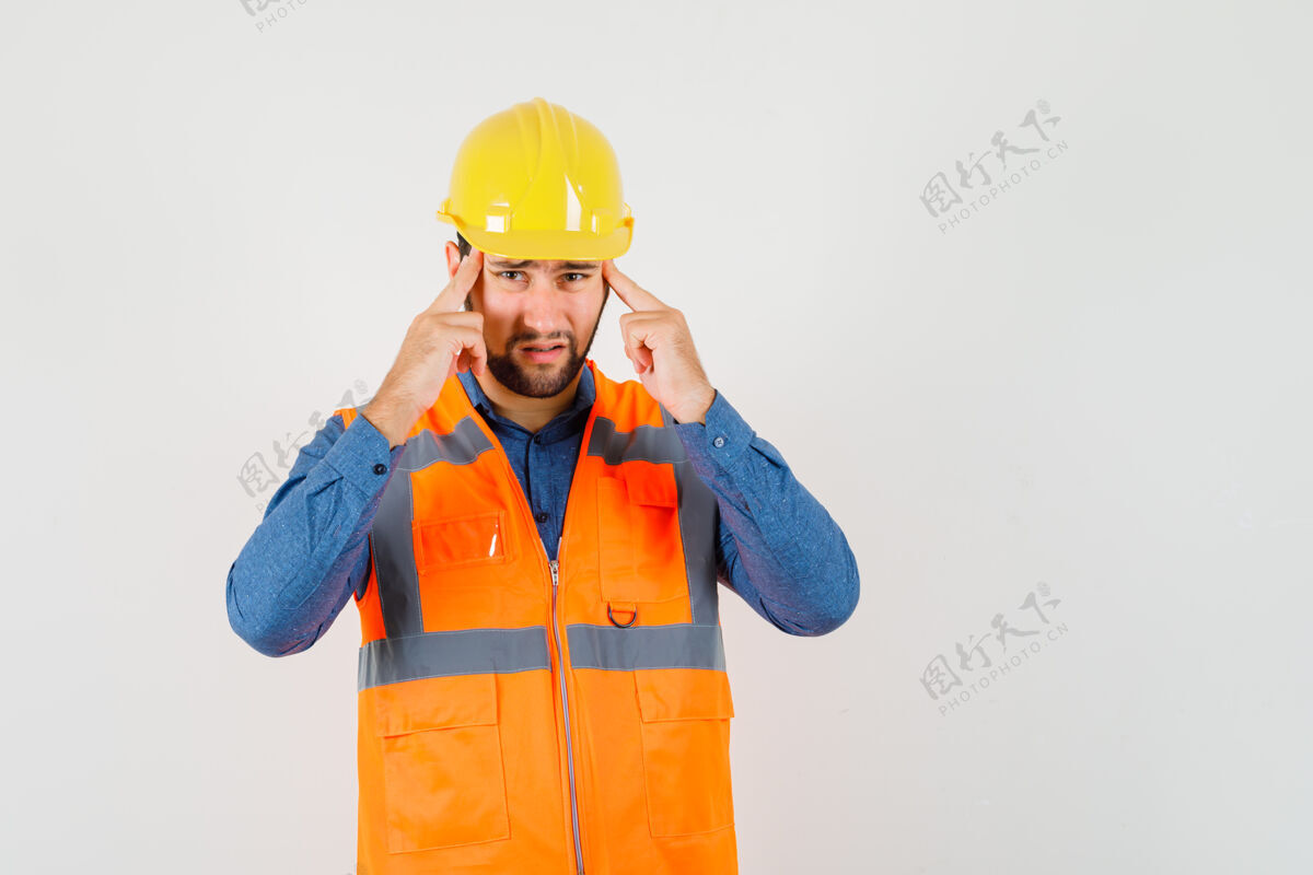 背心年轻的建筑工人在衬衫 背心 头盔遭受强烈的头痛和看起来很累 前视图工人头盔工作