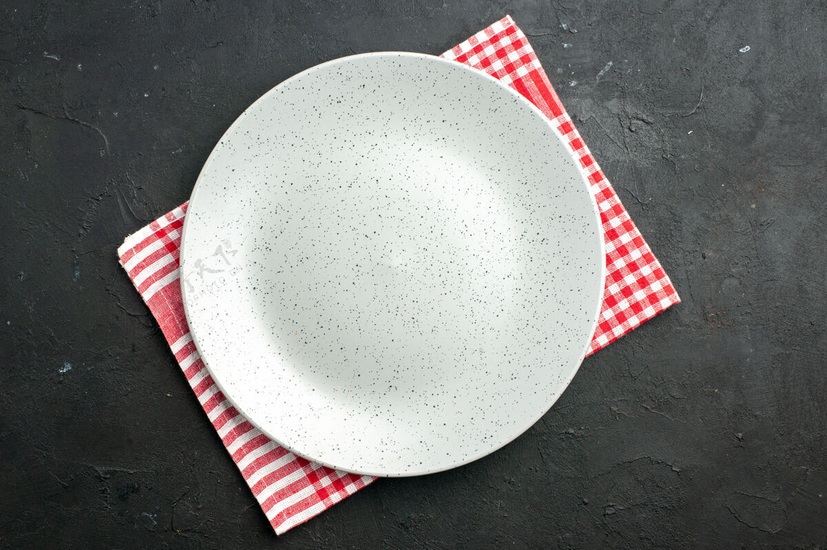 餐巾顶视图白色圆形餐巾纸板在黑暗的桌子上器皿玻璃碗