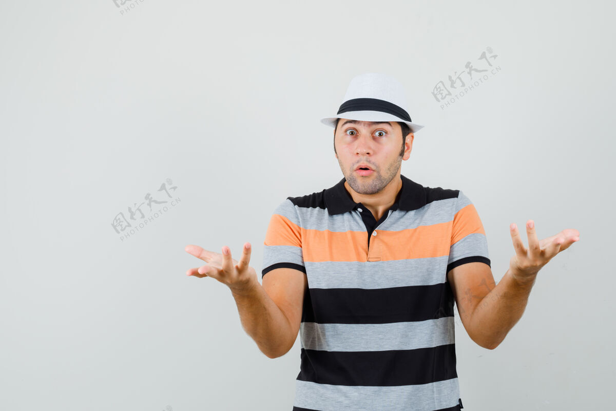 T恤一个穿着条纹t恤 戴着帽子的年轻人表现出无助的姿态 看上去很担心商人长相衬衫