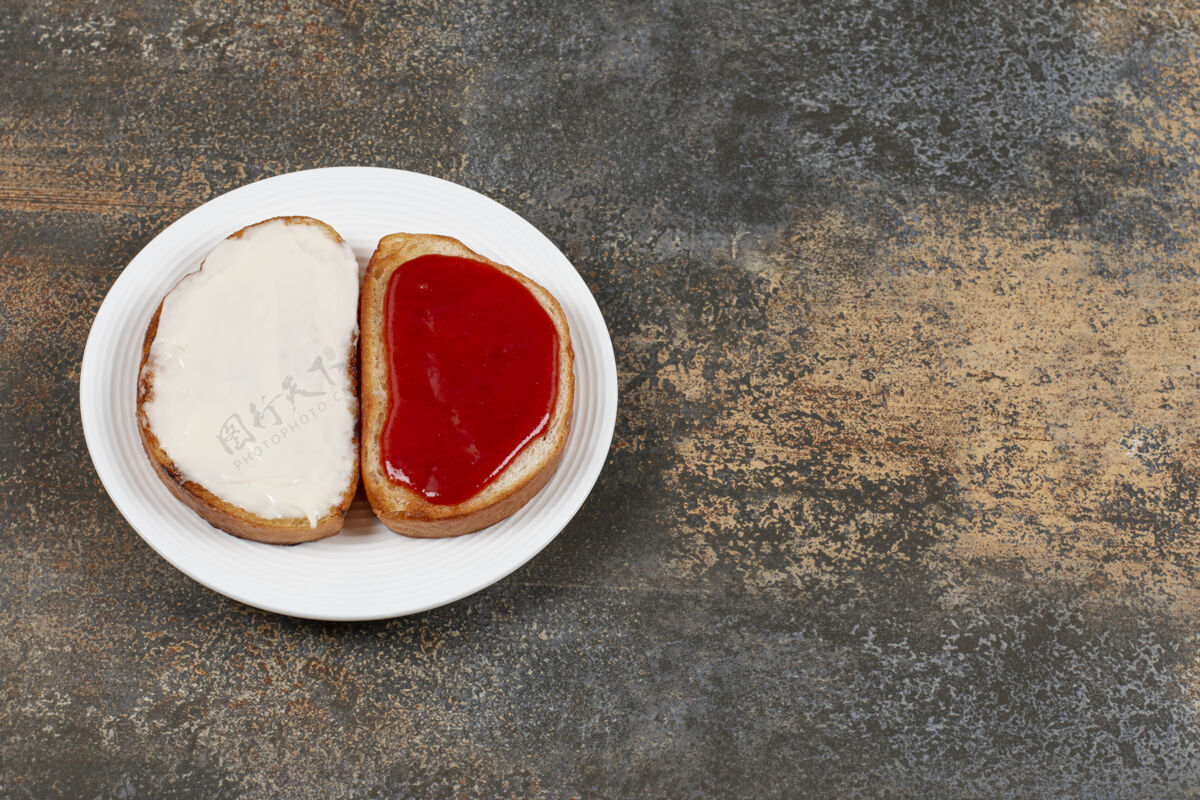 面包在白色盘子上烤草莓酱和酸奶油小吃奶油开胃菜