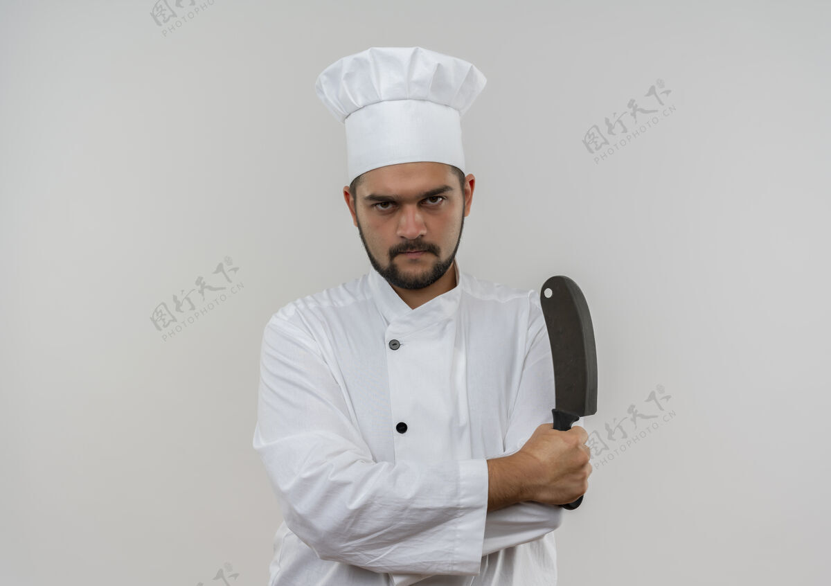 未出租穿着厨师制服的年轻男性厨师站在那里 姿势紧闭 拿着菜刀孤立地站在空白处男性制服复制