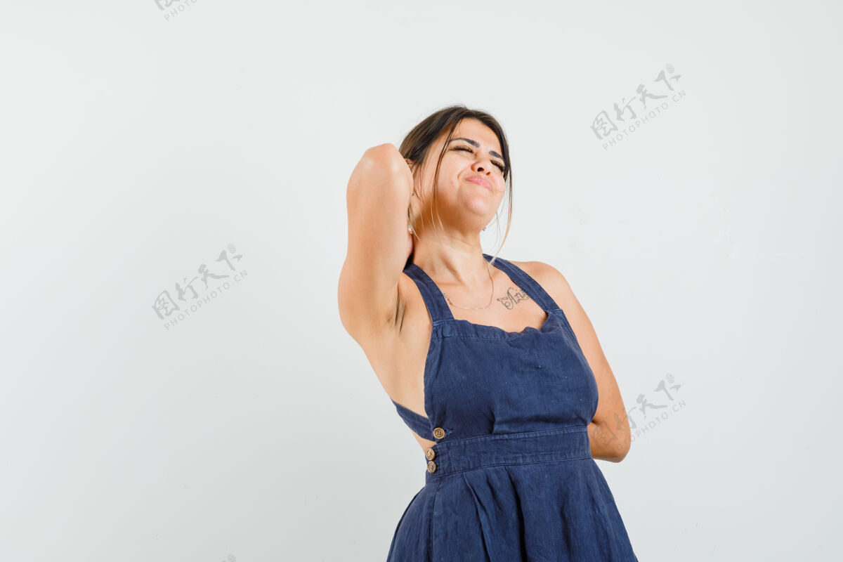 积极穿着连衣裙的年轻女子伸开双臂 看上去很放松年轻乐趣相机