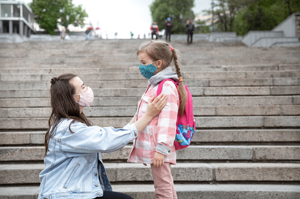 孩子妈妈带着她的小女儿 一个女学生在上学的路上走过台阶冠状病毒大流行的教育理念女儿教育在一起