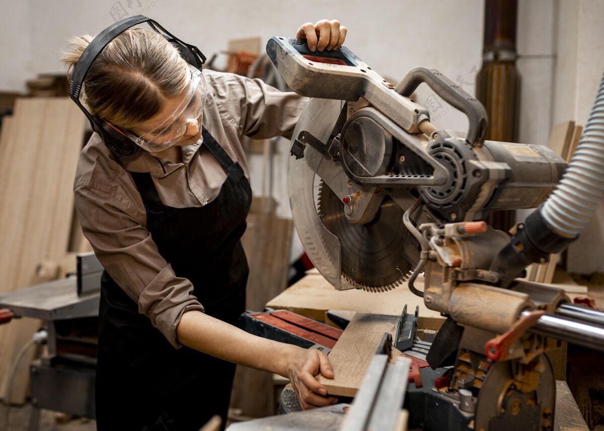 劳动者女木匠在工作室用电锯木匠专业知识工作