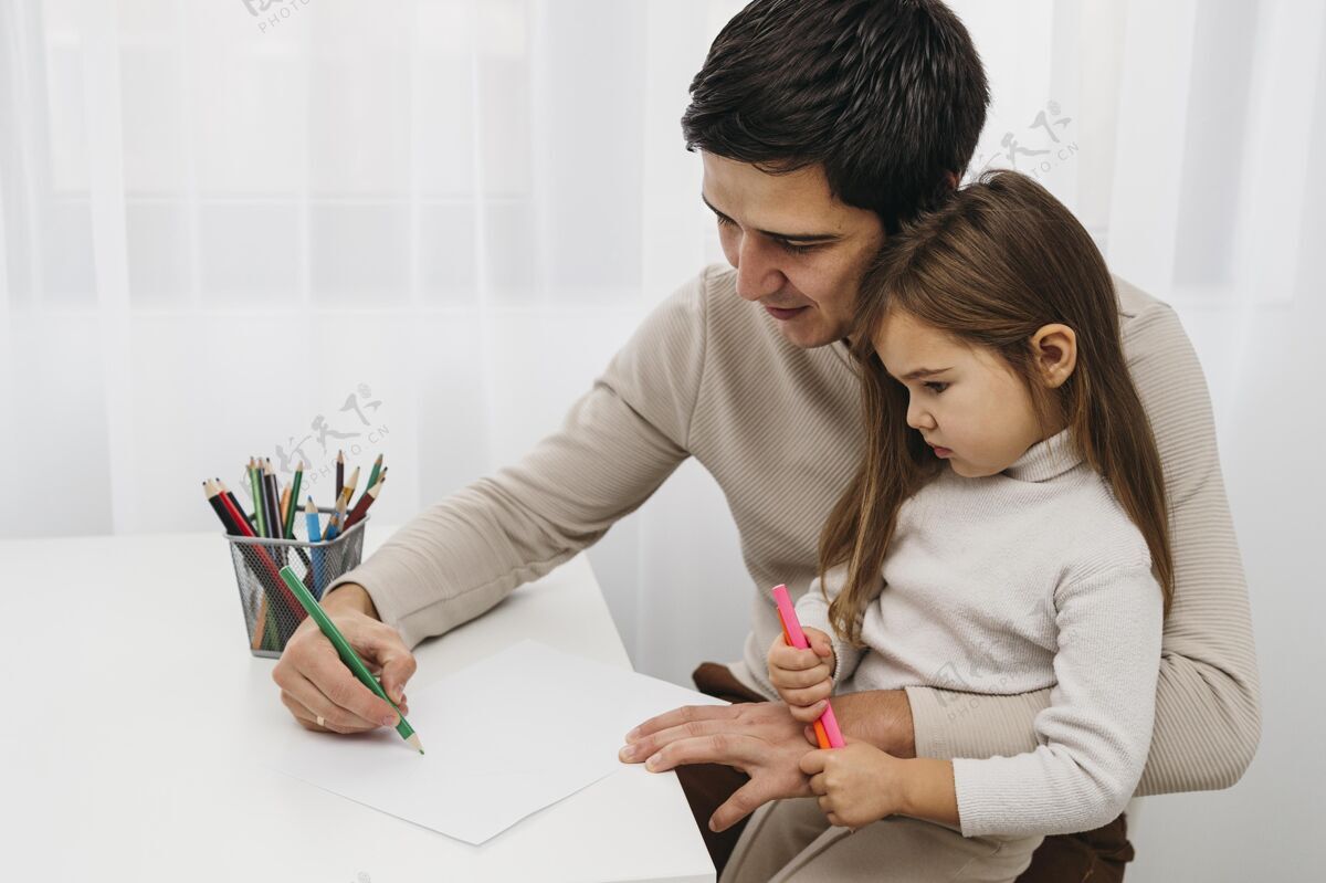 男人爸爸和女儿玩蜡笔家庭父母在一起