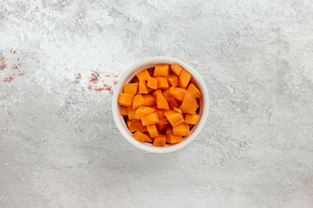 维生素俯视图切碎的橙色蔬菜在白色背景上的小锅里背景锅健康