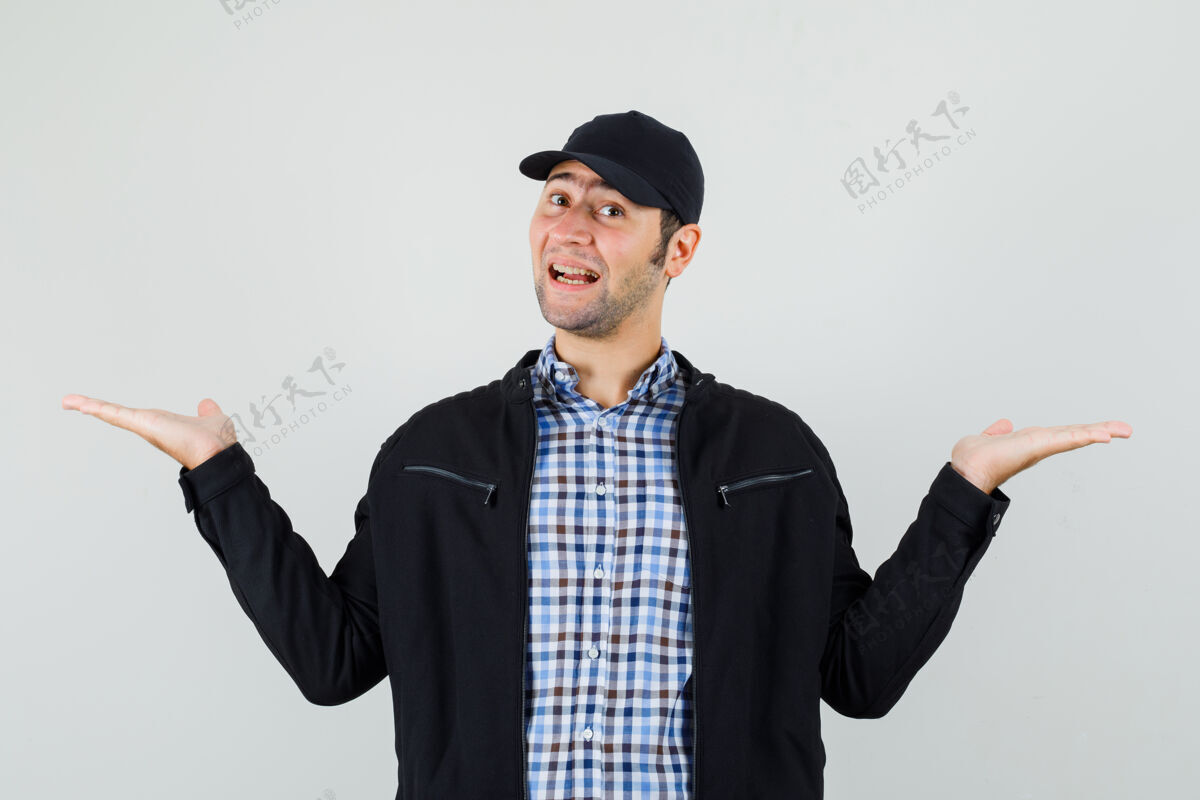成功年轻人在衬衫 夹克 帽子上做秤的手势 看上去很高兴男人欢快鳞片