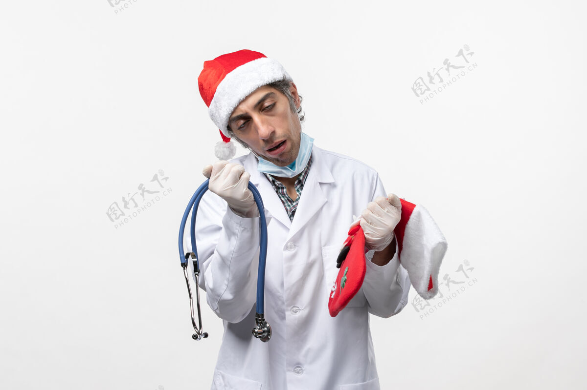 病毒正面图男医生拿着节日袜白墙病毒covid节日健康医院圣诞节听诊器