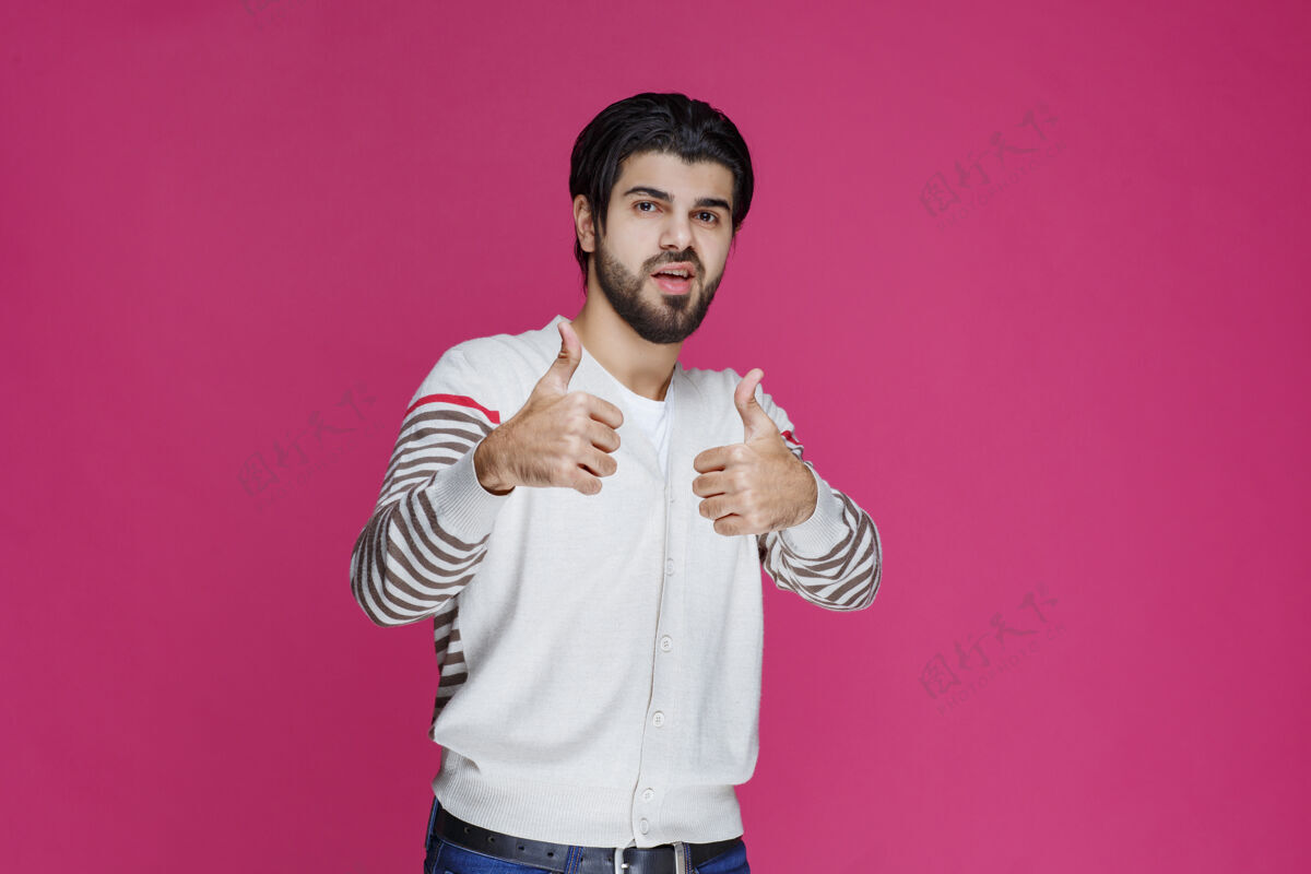 聪明一个穿白衬衫的男人在做竖起大拇指的招牌男性摆姿势享受