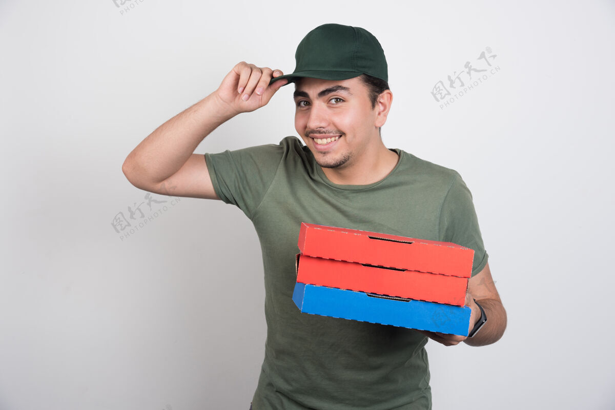 送货员快乐的信使拿着三盒披萨和他的白底帽子肖像送货年轻人