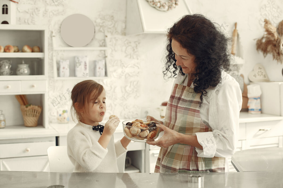 黑发厨房里的人祖母带着小女儿成年妇女给小女孩饼干人女人成人