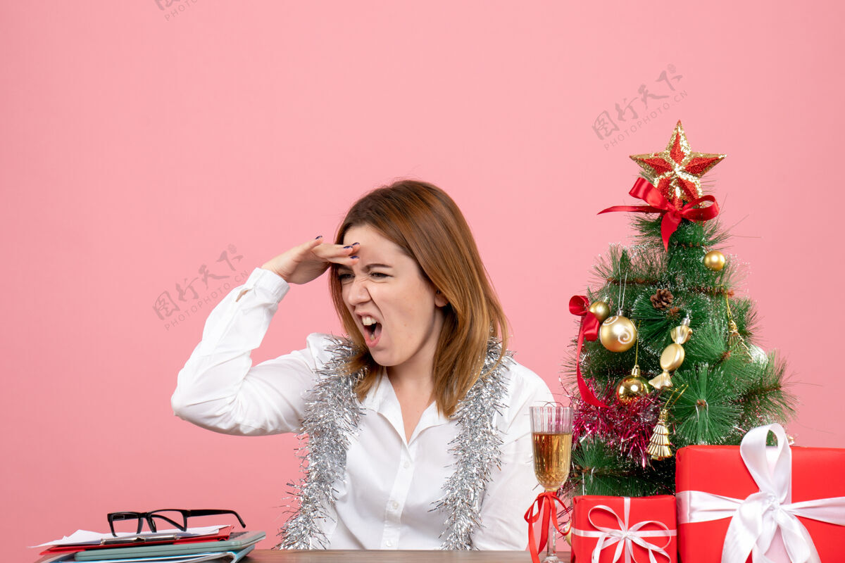 工人女工人坐在桌子后面 粉色的圣诞礼物工作礼物坐着