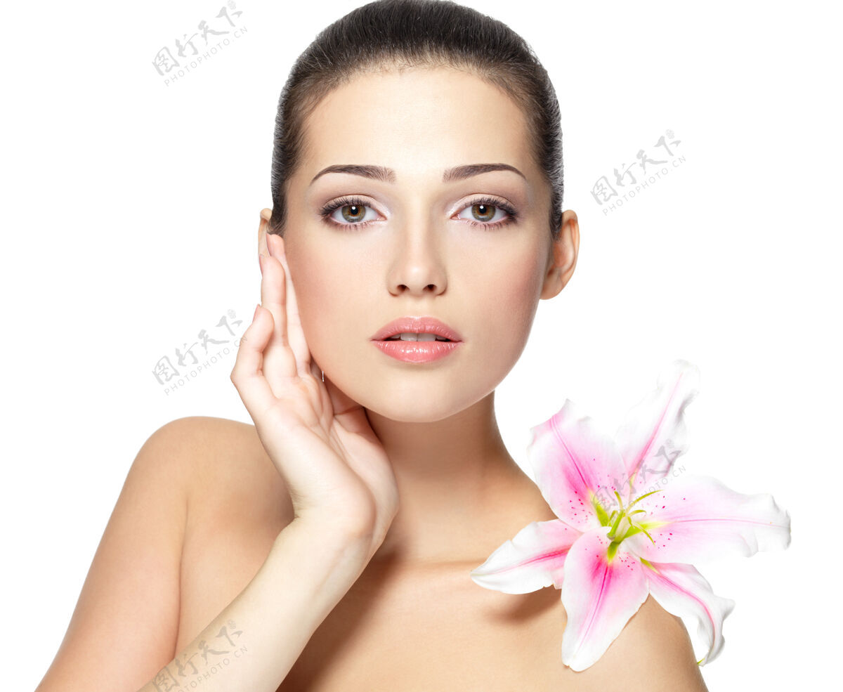 花美丽的年轻女子的脸与花美容治疗的概念肖像在白色的背景花瓣白种人女孩