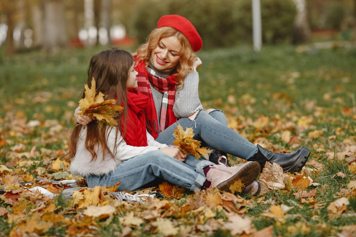 开朗时髦的母亲带着女儿黄色的秋天戴着红领巾的女人衣服户外快乐