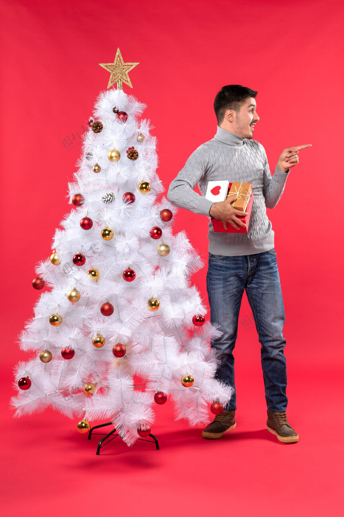 树穿着灰色上衣的浪漫帅哥站在装饰过的白色圣诞树旁衣服有人衬衫